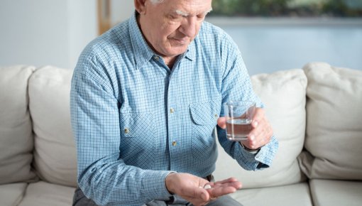Photo of an elderly man taking antibiotics