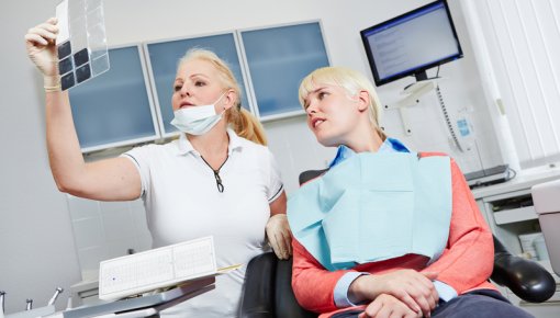 Photo of a dentist discussing an x-ray with a patient
