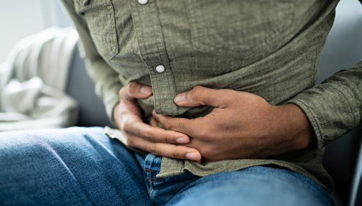 Photo of a man holding his belly in pain